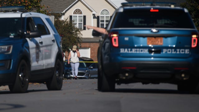A resident walks in the Hedingham neighborhood of Raleigh, North Carolina, on October 14, 2022, a day after a deadly shooting in the area. 
