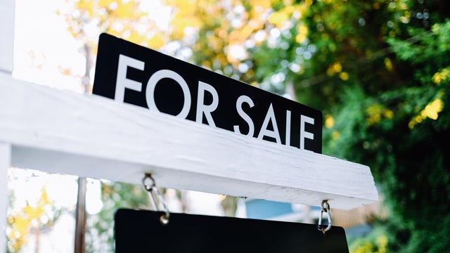 For Sale Sign in Front Yard of House 