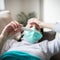 Person wearing a mask and checking their temperature for fever 