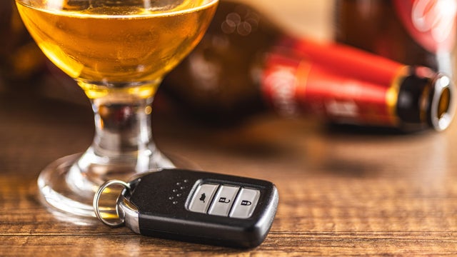 Car key with beer glass on wooden table. Booze driving concept. Drunk driver concept. 