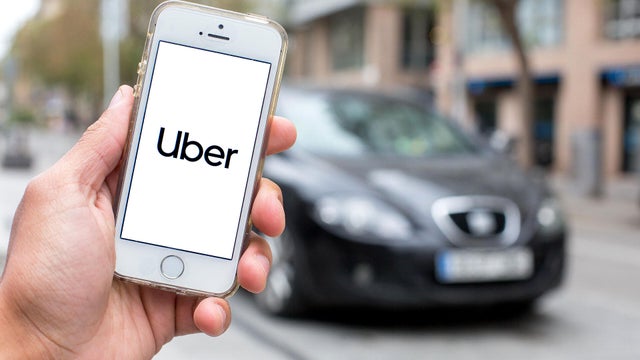 In this photo illustration a Uber logo seen displayed on a 