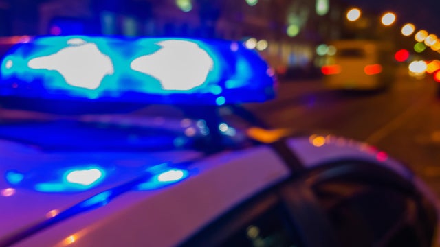 Police car lights in night time, crime scene. Night patrolling the city. Abstract blurry image. 